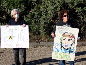 'Don't Let Boeing Fool You' and 'Burn Your Shoes Your On Contaminated Grounds' protest signs at SSFL